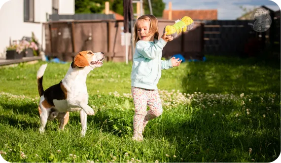 dziecko bawiące się z psem aktywnie w ogrodzie